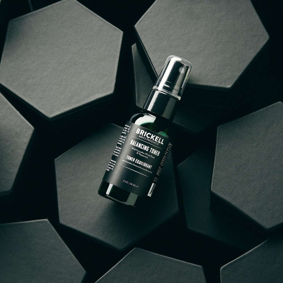 Brickell toner held in hand to show 2 ounce scale and travel-friendly benefit