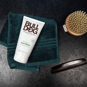 Bulldog face wash beside toiletries to show travel scale and portability benefits