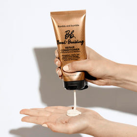 Bumble and bumble conditioner being applied to wet hair for detangling benefit