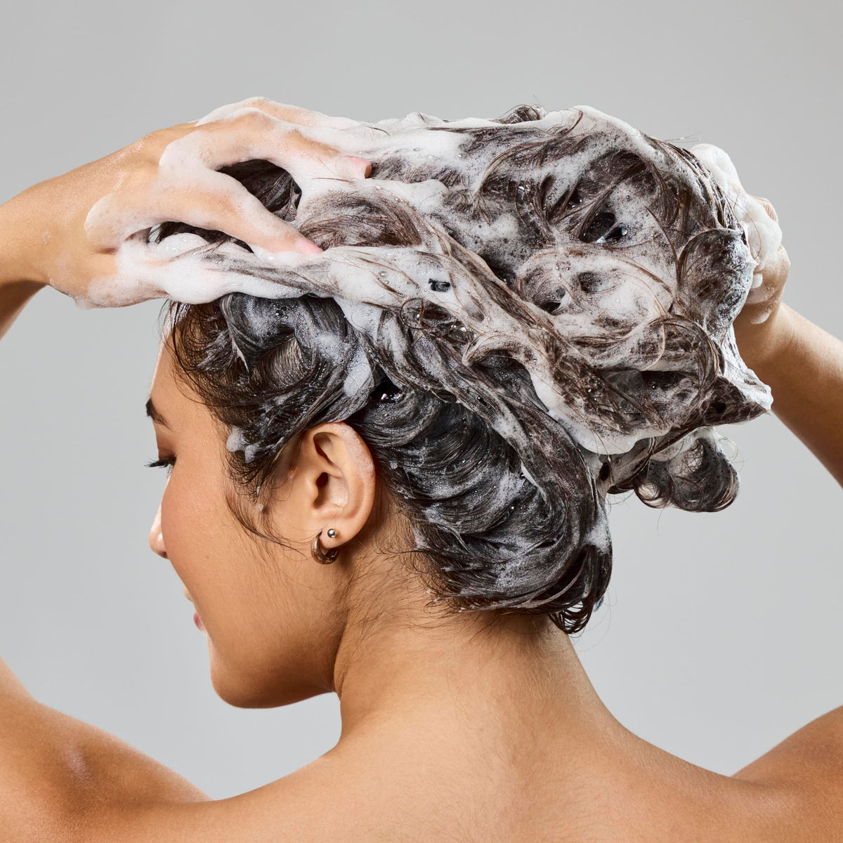 Bumble and bumble. creamy shampoo texture close-up showing rich hydrating lather