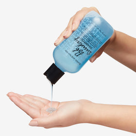 Bumble and bumble bottle in hand showing 8.5 fl oz scale benefit