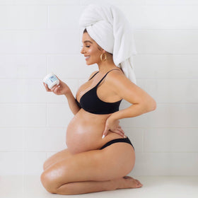 Bumpology being massaged onto pregnant belly to support elasticity