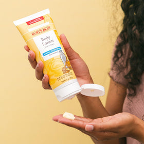 Burt's Bees lotion texture poured from bottle highlighting creamy, fast-absorbing formula