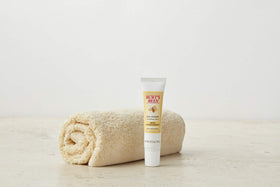 Burt's Bees product next to coin to show compact 0.5 oz size