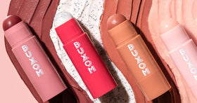 BUXOM Dolly Fever lifestyle bag shot next to essentials showing everyday convenience