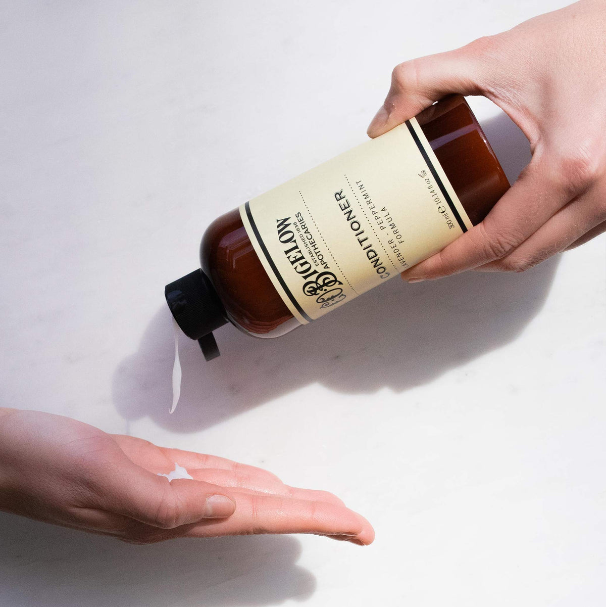 C. O. Bigelow conditioner in hand demonstrating amount for detangling ease