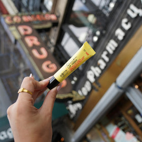 C. O. Bigelow tube held in hand to show compact 0.5 oz size for travel
