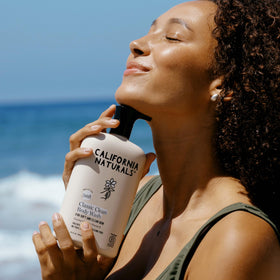 California Naturals bottle in shower hand demonstrating soft, hydrated skin benefit