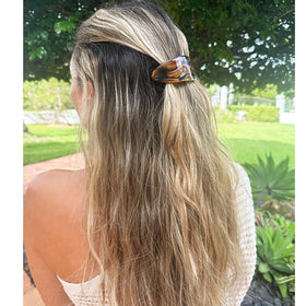 Camila barrette next to a hand to indicate 4-inch scale and capacity for large hair amounts