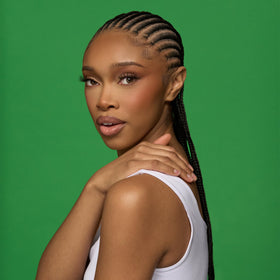 Camille Rose applying leave-in to damp hair demonstrating detangling benefit