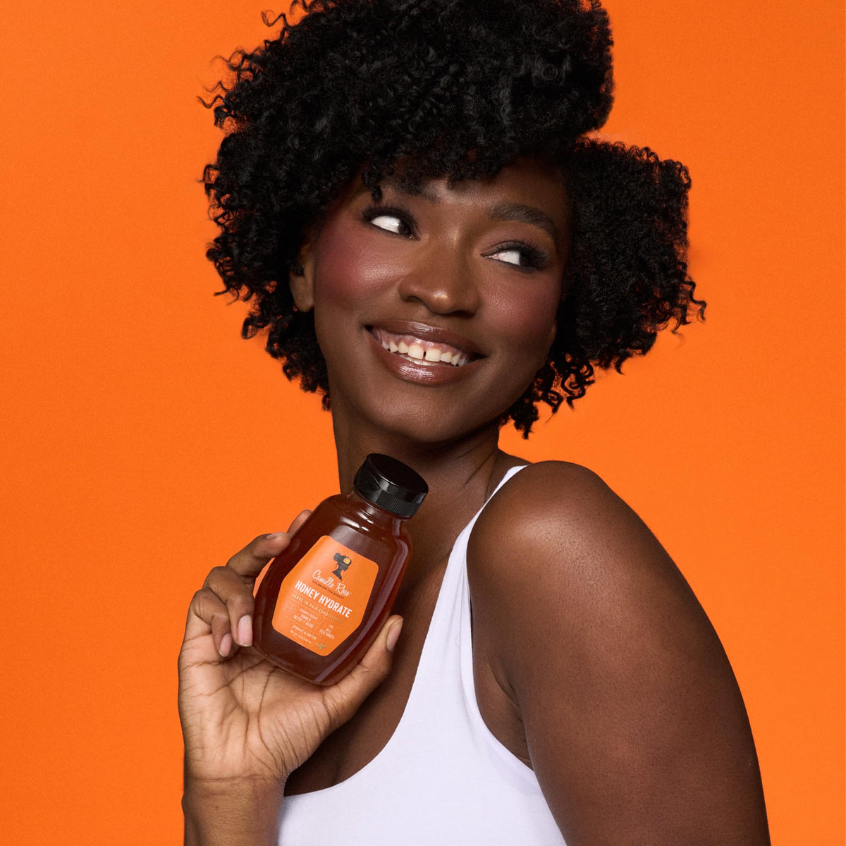 Camille Rose 8 oz bottle in hand showing travel-friendly size