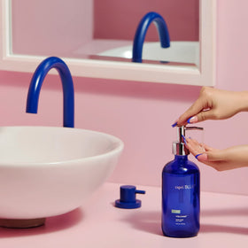 Capri Blue bottle on sink displaying refillable glass and decorative pop of color