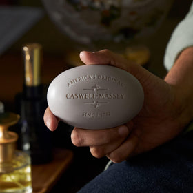Caswell-Massey bar held in hand showing size and long-lasting usage benefit