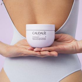 Caudalie jar styled on bathroom shelf, lifestyle scene suggests daily ritual