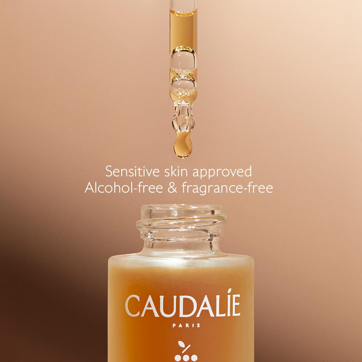 Caudalie 15 mL bottle next to fingers showing compact travel-friendly size benefit