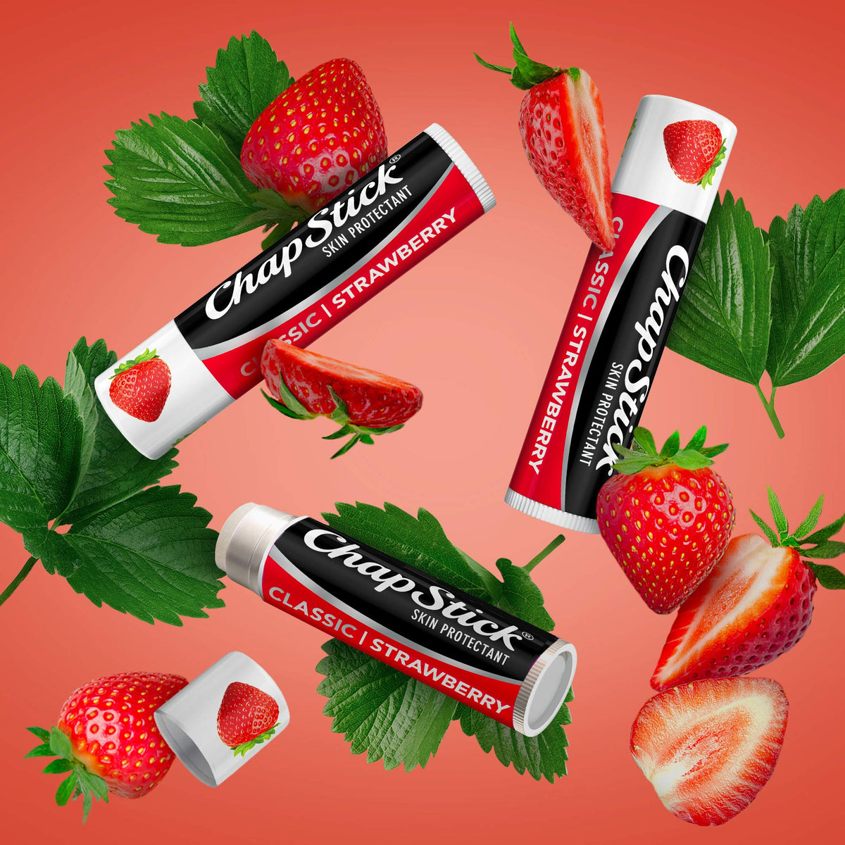 ChapStick tubes staged with fresh strawberries conveying fruity scent and freshness