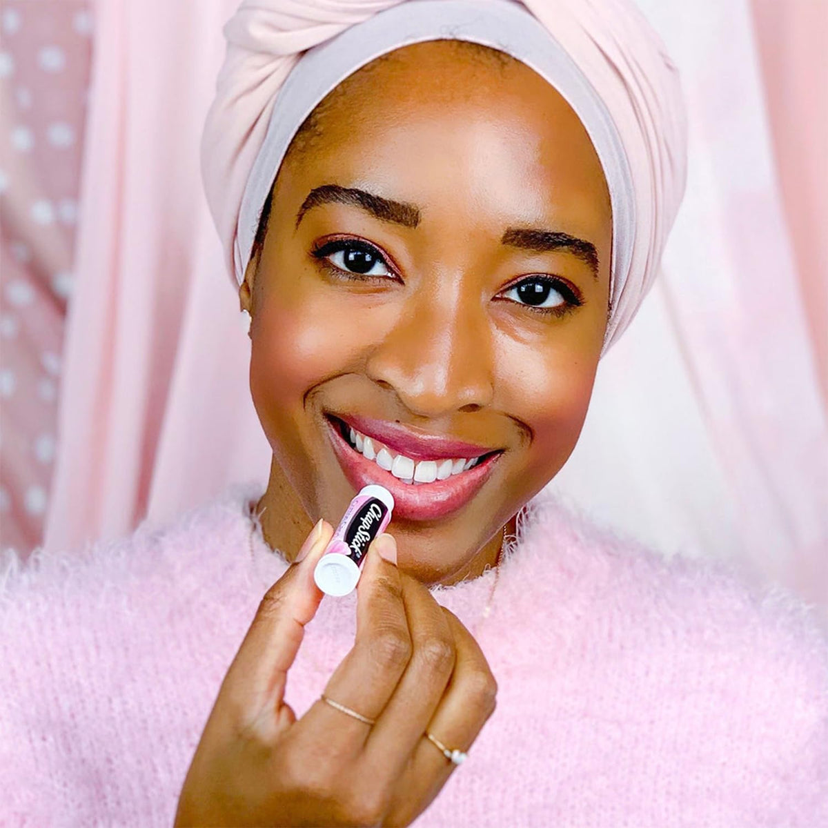 ChapStick tube in hand showing size and portability of Cotton Candy