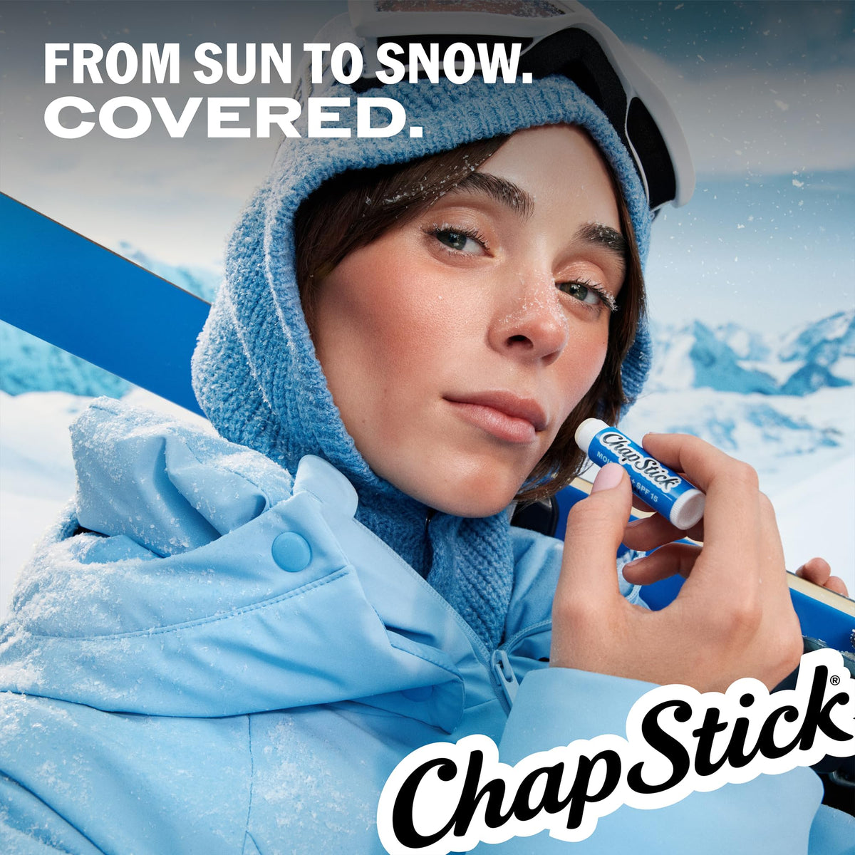 person applying ChapStick at the beach demonstrating sun protection benefit