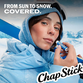 person applying ChapStick at the beach demonstrating sun protection benefit