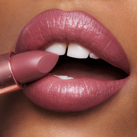 Charlotte Tilbury lipstick in hand to show size and portable, travel-friendly benefit