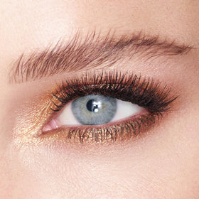 Charlotte Tilbury swatch on skin showing metallic amber-gold payoff and versatile warmth benefit