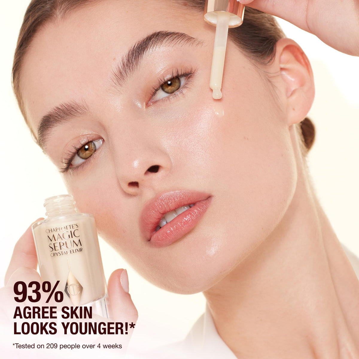 Charlotte Tilbury applying serum on face for firmer-looking, pre-makeup skin