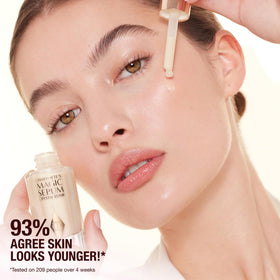 Charlotte Tilbury applying serum on face for firmer-looking, pre-makeup skin