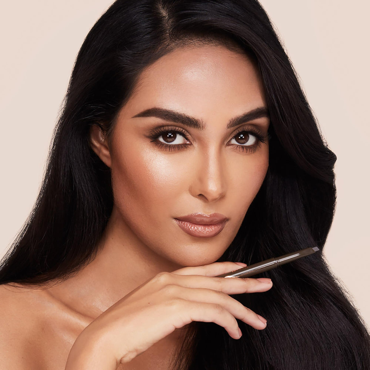 Charlotte Tilbury Brow Cheat size scale in hand showing portability and precision control