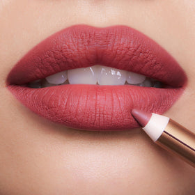 Charlotte Tilbury pencil held in hand to show size and portability
