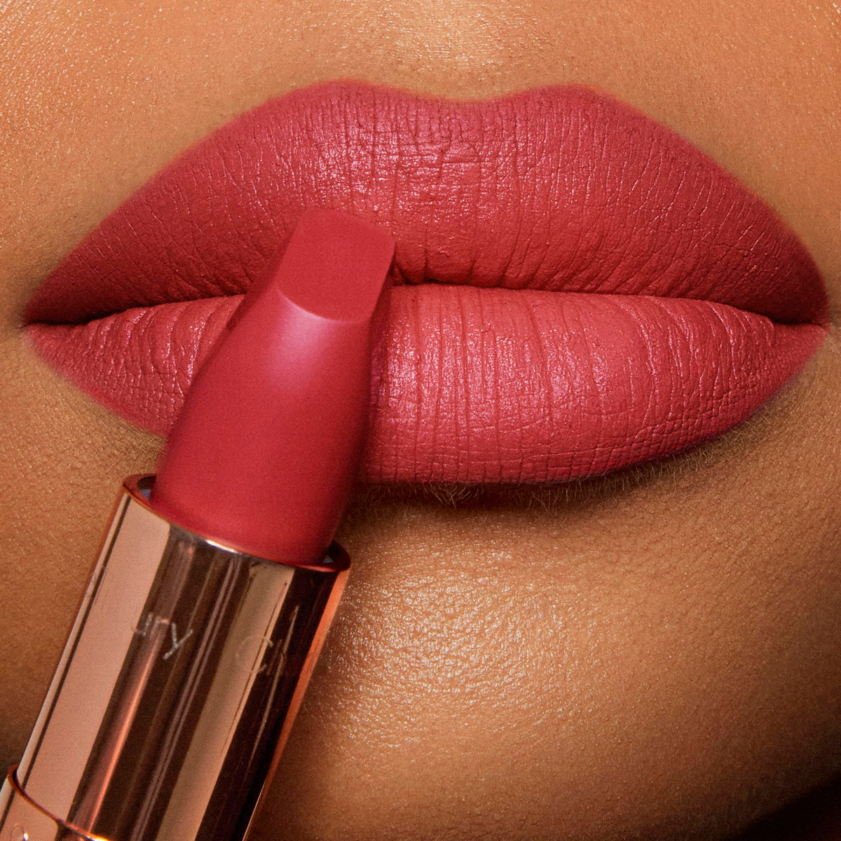 Charlotte Tilbury lipstick swatch on arm demonstrating vibrant fuchsia payoff