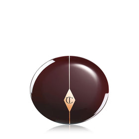 Charlotte Tilbury compact next to coin size comparison showing portable, purse-friendly design