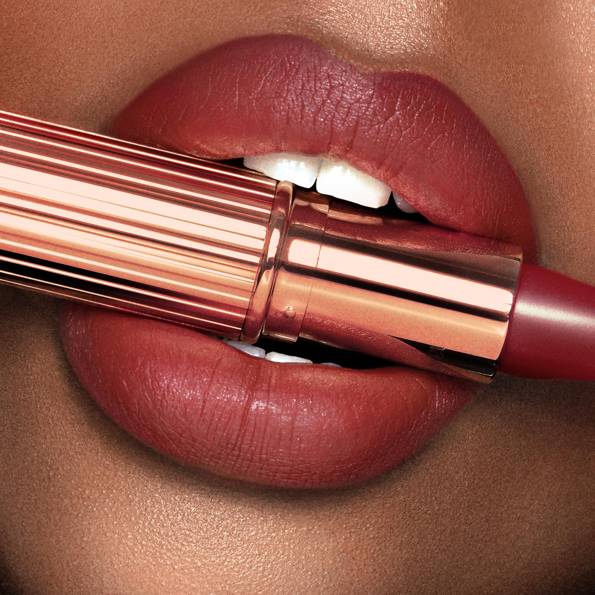 Charlotte Tilbury applying lipstick to lips in mirror showing easy glide benefit: quick everyday use