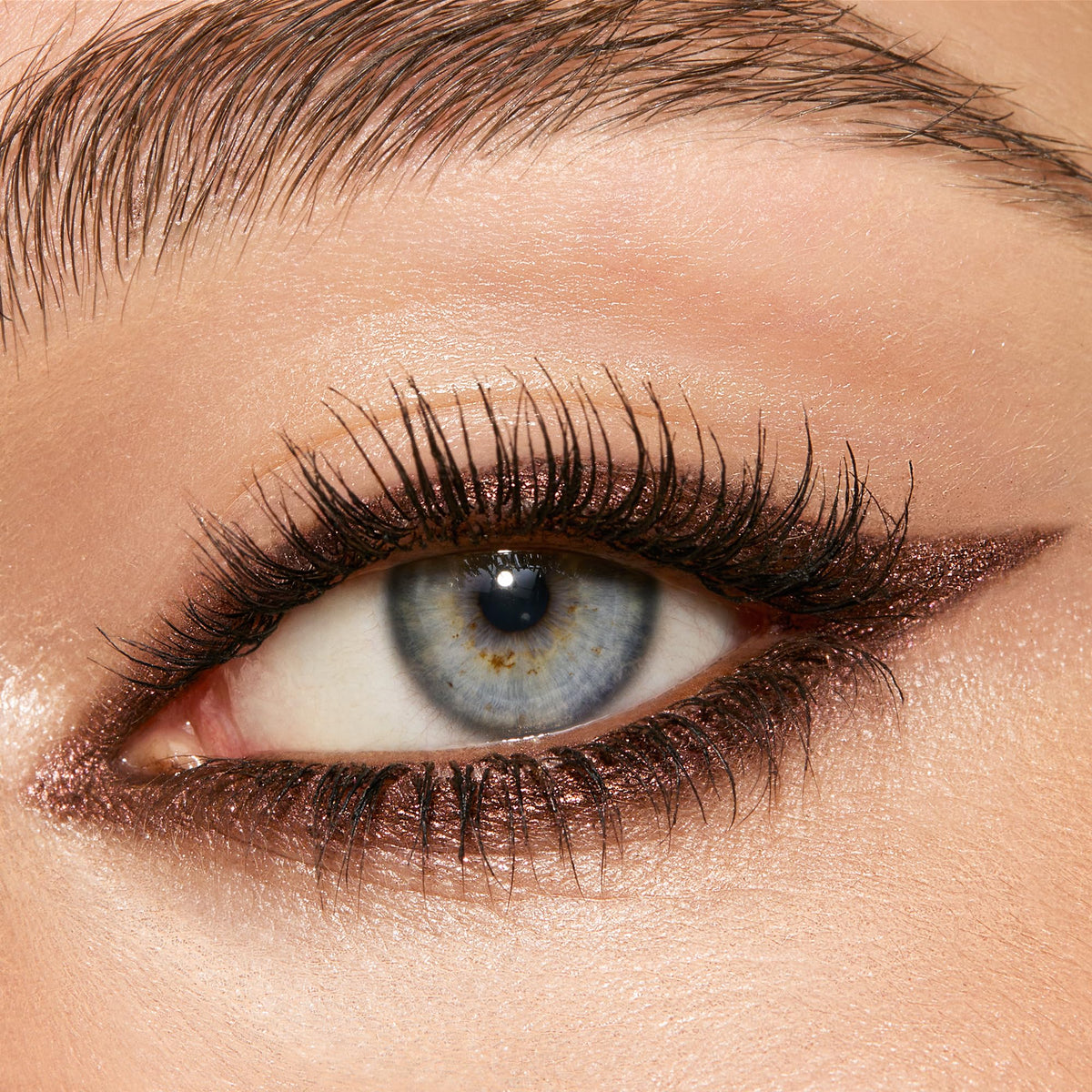 Charlotte Tilbury swatches of Smokey Bronze on skin illustrating metallic bronze payoff and blendability