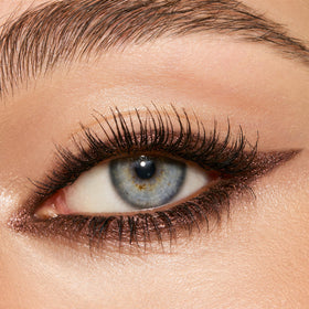 Charlotte Tilbury swatches of Smokey Bronze on skin illustrating metallic bronze payoff and blendability