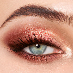 Charlotte Tilbury shimmer shade swatched on skin showing luminous pop for center lid benefit