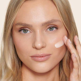Charlotte Tilbury skin tint held in hand to show size and portability for on‑the‑go use