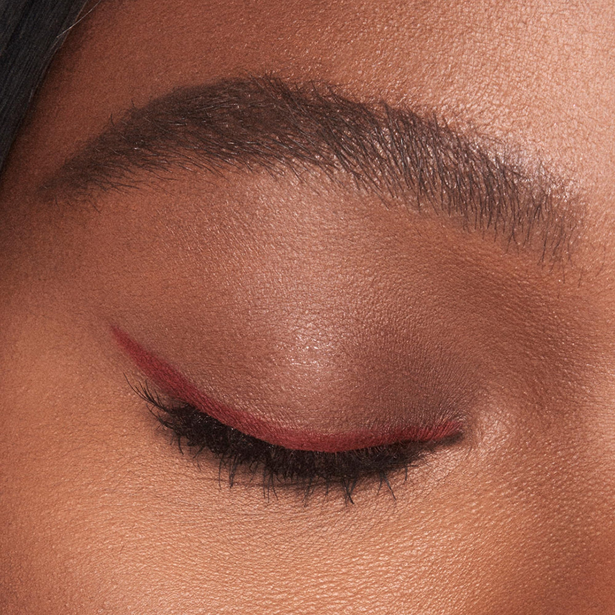 Charlotte Tilbury pencil styled on a vanity with lipstick, suggesting coordinated, flattering looks