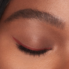 Charlotte Tilbury pencil styled on a vanity with lipstick, suggesting coordinated, flattering looks