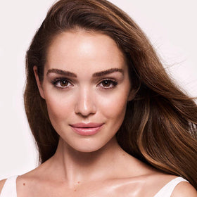 Charlotte Tilbury skin close-up showing subtle sheen and soft-focus smoothing on complexion