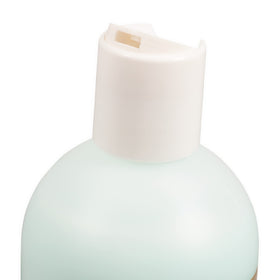 Chris Christensen bottle held in hand showing 16 oz scale and travel-friendly benefit