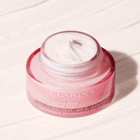Clarins cream applied to cheek in demo illustrating refined texture benefit