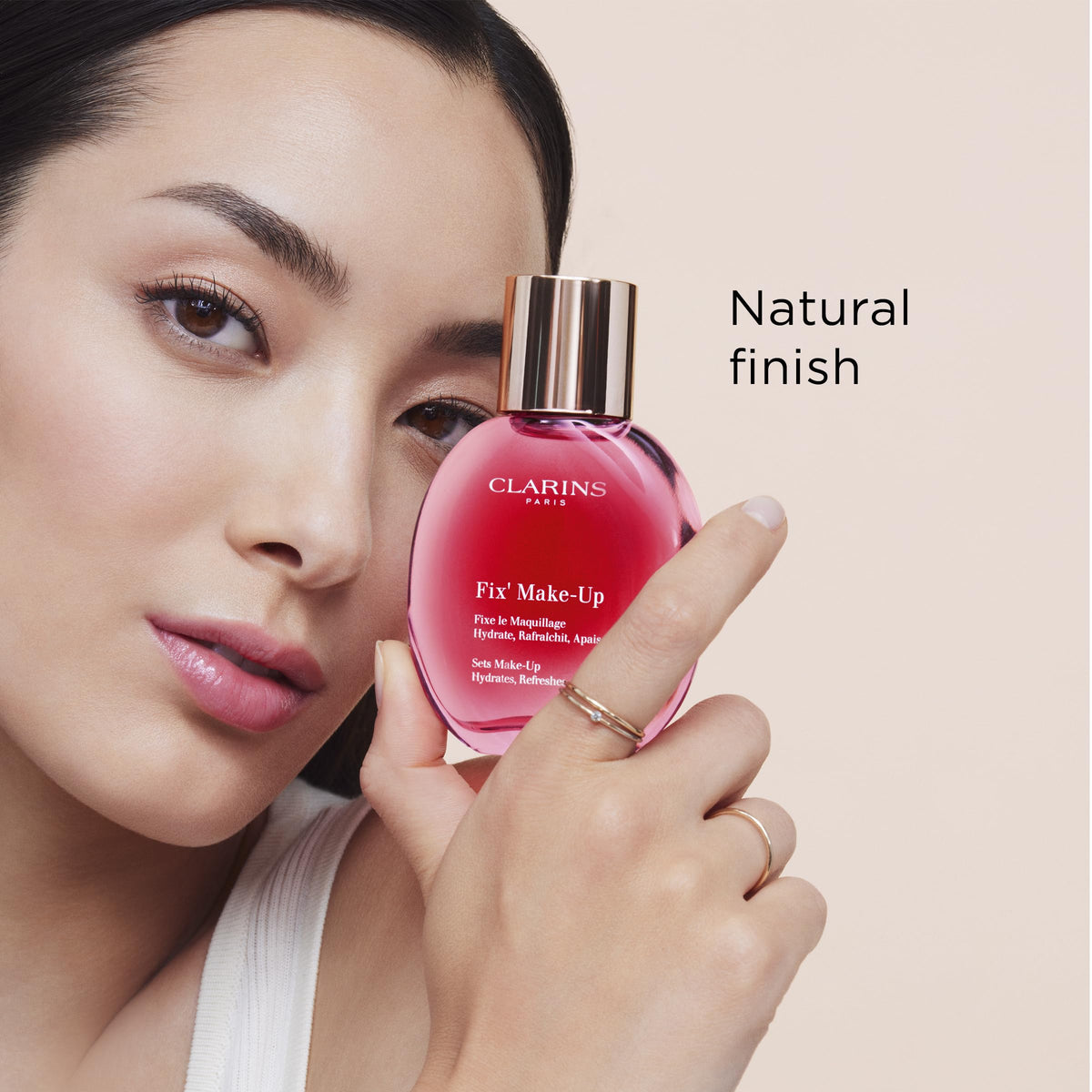 Clarins spray held in hand showing compact travelable size benefit