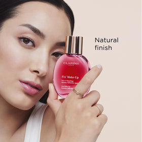 Clarins spray held in hand showing compact travelable size benefit