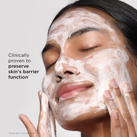 Clarins bottle in hand indicating compact 4.2 ounce travel-friendly size
