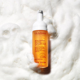 Clarins 5.5 oz bottle next to ruler for clear size and travel-friendly benefit