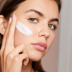 Hand applying Clarins cream demonstrating quick absorption benefit