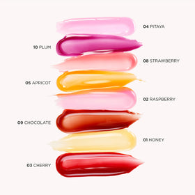 Clarins lip comfort oil size scale next to coin showing travel-friendly compact packaging