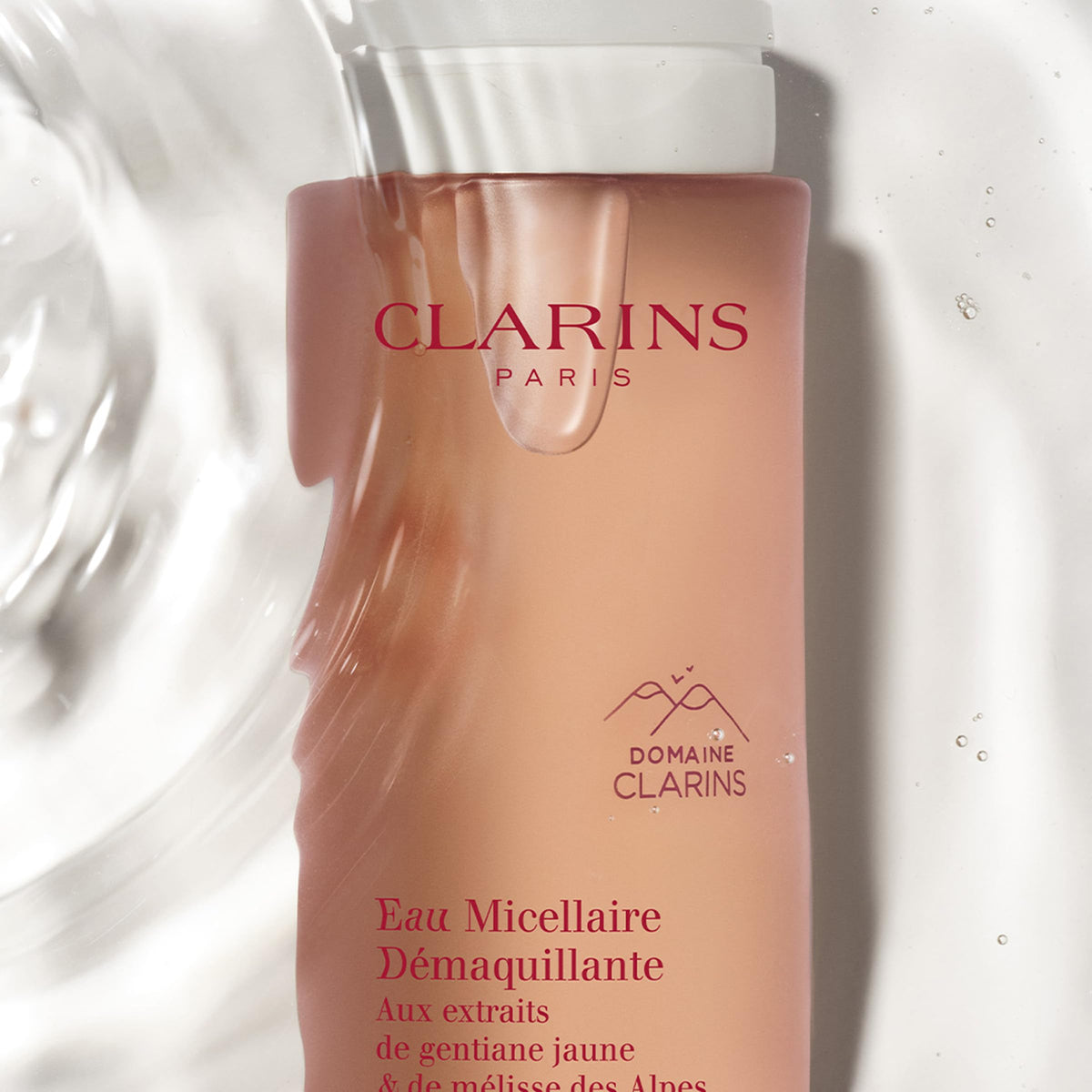 Clarins bottle in hand to show size and convenient travel-friendly benefit
