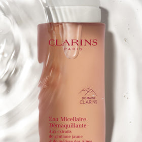Clarins bottle in hand to show size and convenient travel-friendly benefit