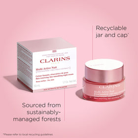 Clarins jar next to everyday objects for scale, shows compact travel-friendly size